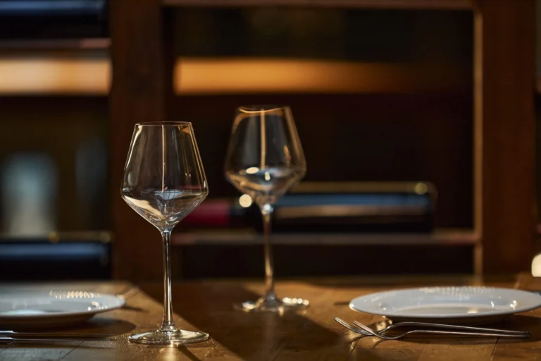 Empty wine glasses and plates set on a restaurant table