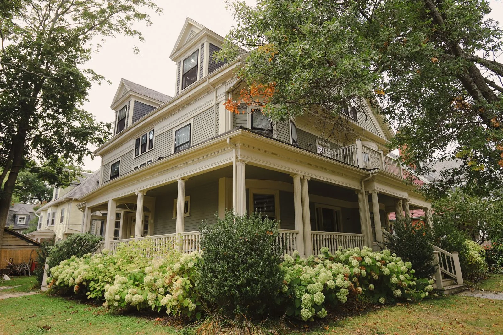 Traditional home with a wraparound porch and flowering garden