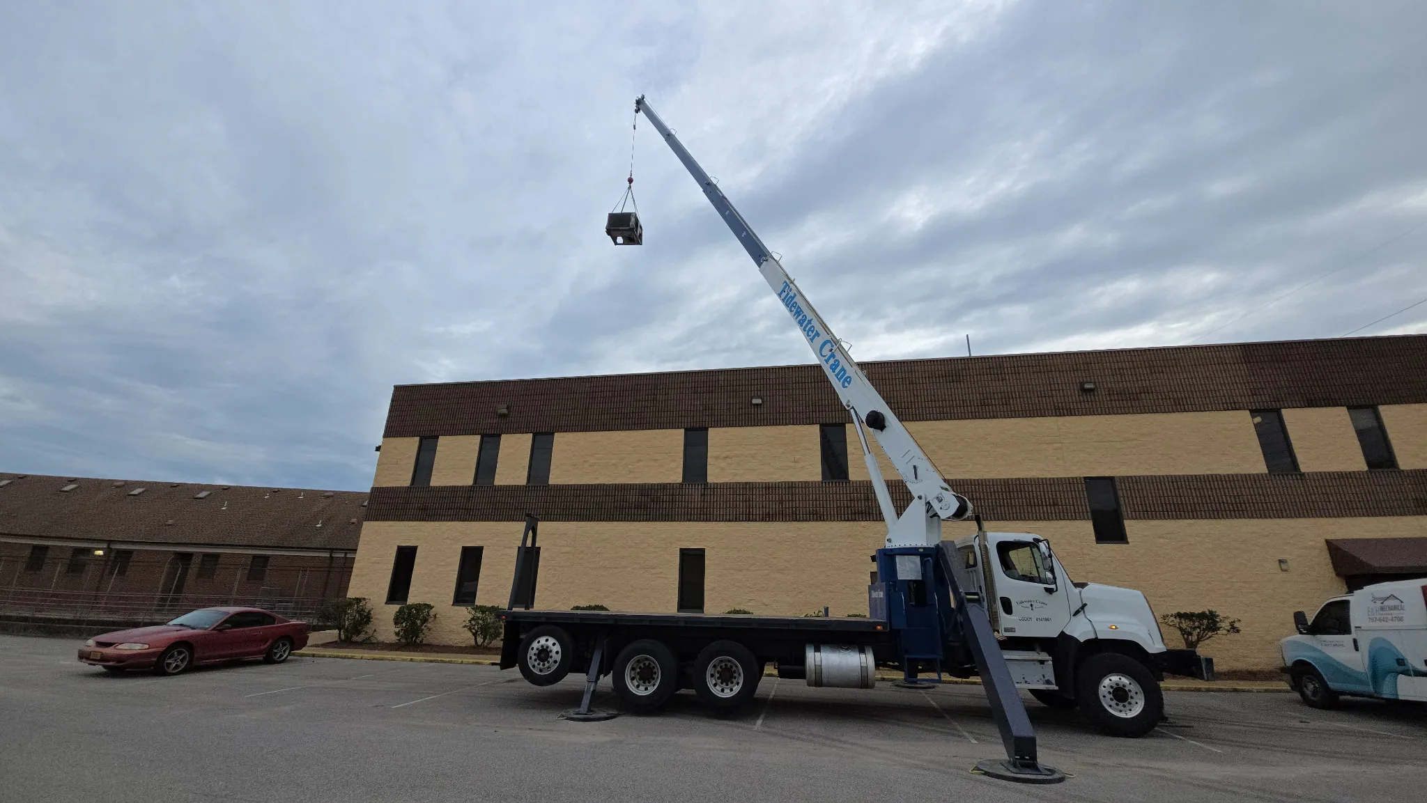 Crane lifting rooftop equipment during an E&H Mechanical commercial HVAC project.