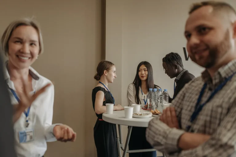 Adults talking over refreshments during a business networking break.