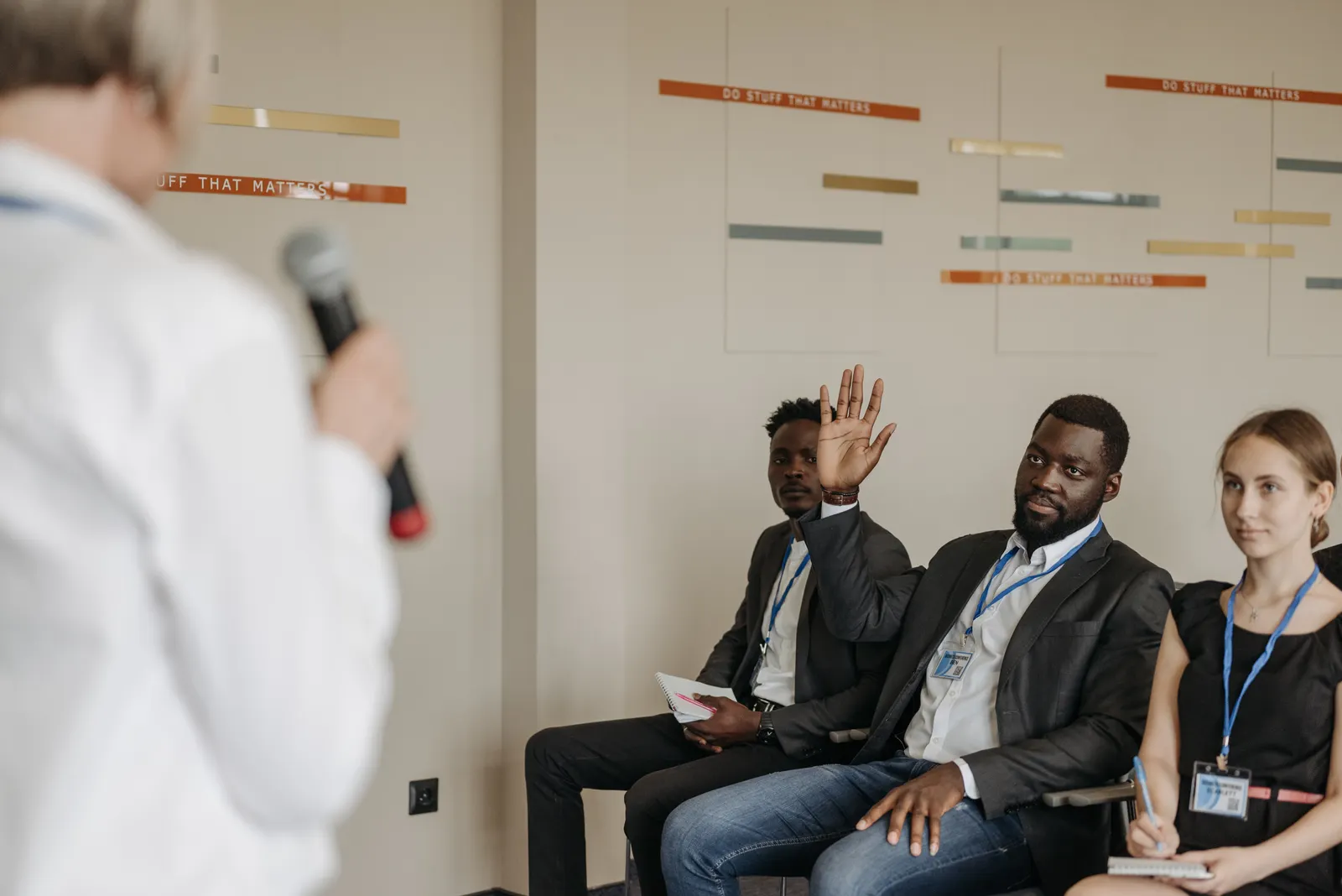 An audience member raises his hand during a business workshop.